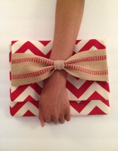 Clutch with bow features a hand thru detail. 